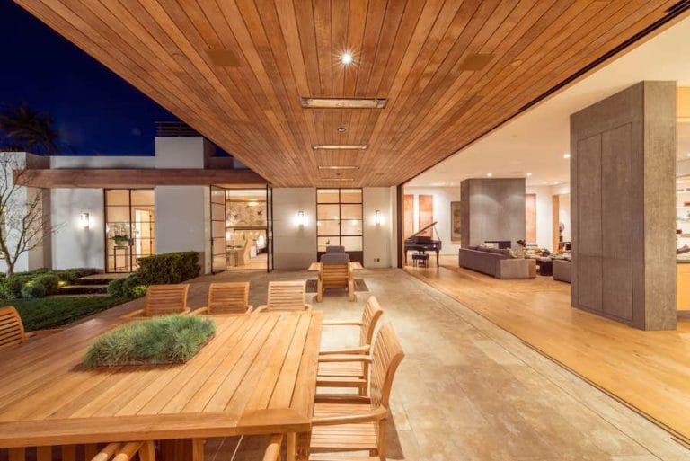 A luxurious home with indoor areas opening up to an expansive outdoor patio.