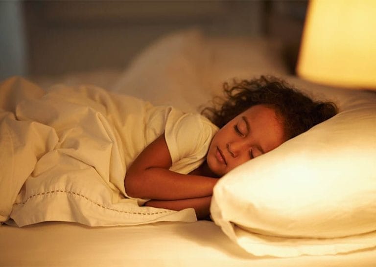 A young child sleeping in a bed.